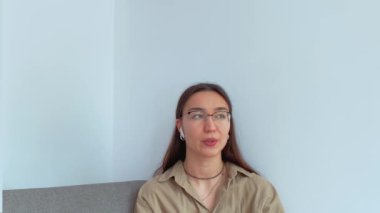 Kulaklıklı genç ve çekici bir kız telefonda konuşuyor ve online danışmanlık yapıyor. - Evet. Yüksek kalite 4k görüntü