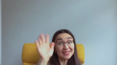 Genç ve çekici bir kız arkadaşlarını selamlamak için elini sallıyor. Yüksek kalite FullHD görüntüler.