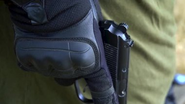 Bir asker ateşe hazırlanan dolu bir tabanca tutar. Yüksek kaliteli FullHD görüntüler