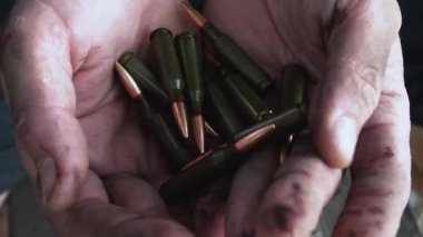 Asker kanlı ellerinde mermiler tutuyor. Yüksek kaliteli FullHD görüntüler