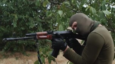 Profesyonel bir asker makineli tüfeğini düşmana doğrultur. Yüksek kalite 4k görüntü
