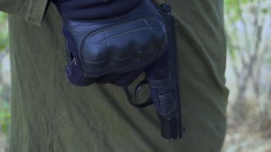 Bir asker ateşe hazırlanan dolu bir tabanca tutar. Yüksek kaliteli FullHD görüntüler