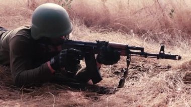 Profesyonel bir asker makineli tüfeğini düşmana doğrultur. Yüksek kalite 4k görüntü