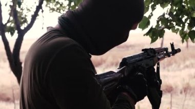 Profesyonel bir asker makineli tüfeğini düşmana doğrultur. Yüksek kalite 4k görüntü