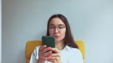 Genç ve çekici bir kız erkek arkadaşıyla cep telefonunda konuşuyor. Yüksek kaliteli FullHD görüntüler