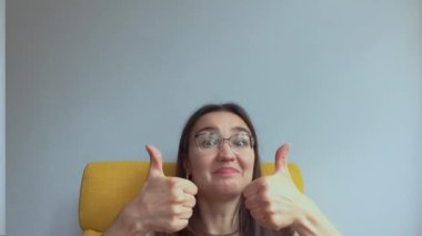 Genç ve çekici bir kız şaşırdı ve baş parmağını kaldırdı. Yüksek kalite 4K görüntü.