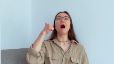 Genç ve çekici bir kız gülümsüyor ve baş parmağını kaldırıyor. Yüksek kalite 4k görüntü