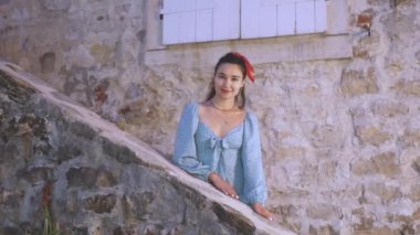 Genç ve güzel bir İspanyol kadın sevgilisine hava öpücüğü yolluyor. Aşık genç bir İspanyol kadın duvarın yanında durur ve sevgilisini bekler..