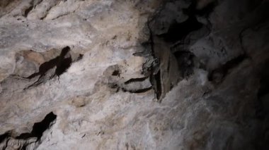 Karanlık bir mağarada muhteşem bir kaya oluşumu. Mağaranın tavanında kocaman sarkıtlar asılı..
