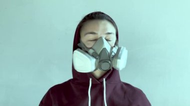 Genç ve çekici bir kız kafasına gaz maskesi takar ve onu nasıl doğru kullanacağını gösterir. Yüksek kalite.