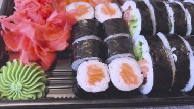 Yemek çubukları Japon restoranında Japon suşisi yer. Geleneksel menü için restoranda suşi, tabak ve aşçının elleri..