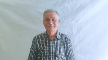 Kareli gömlekli yaşlı bir adam coşkuyla alkışlıyor ve bravo diye bağırıyor. Beyaz arkaplanda bir portre.