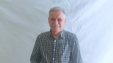 Kareli gömlekli yaşlı bir adam başarısız bir performansı alaycı bir şekilde alkışlıyor. Beyaz arkaplanda bir portre.