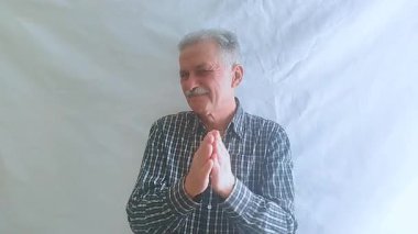 Kareli gömlekli yaşlı bir adam başarısız bir performansı alaycı bir şekilde alkışlıyor. Beyaz arkaplanda bir portre.