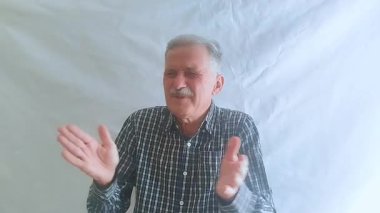 Kareli gömlekli yaşlı bir adam başarısız bir performansı alaycı bir şekilde alkışlıyor. Beyaz arkaplanda bir portre.