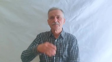 Kareli gömlekli yaşlı bir adam aktif olarak bir sorun düşünüyor ve doğru çözüm ona geliyor. Beyaz arkaplanda bir portre.