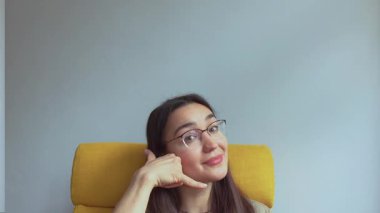  Genç, çekici bir kız elini kulağına koyar ve onu geri aramak için bir işaret yapar. Yüksek kaliteli FullHD görüntüler