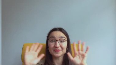 Genç ve çekici bir kız arkadaşlarını selamlamak için elini sallıyor. Yüksek kalite FullHD görüntüler.