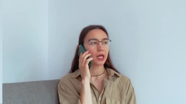 Genç ve çekici bir kız erkek arkadaşıyla cep telefonunda konuşuyor. Yüksek kaliteli FullHD görüntüler