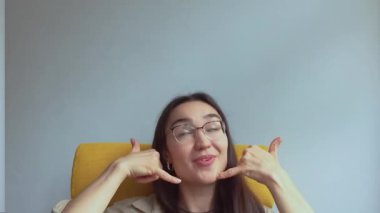  Genç, çekici bir kız elini kulağına koyar ve onu geri aramak için bir işaret yapar. Yüksek kaliteli FullHD görüntüler