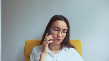 Genç ve çekici bir kız erkek arkadaşıyla cep telefonunda konuşuyor. Yüksek kaliteli FullHD görüntüler