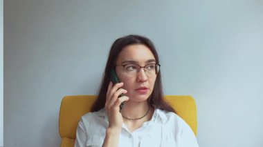 Genç ve çekici bir kız erkek arkadaşıyla cep telefonunda konuşuyor. Yüksek kaliteli FullHD görüntüler