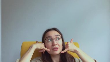  Genç, çekici bir kız elini kulağına koyar ve onu geri aramak için bir işaret yapar. Yüksek kaliteli FullHD görüntüler