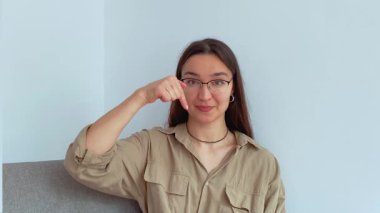 Genç ve çekici bir kız parmağını aşağı indirip onu bağlantıyı takip etmeye davet ediyor. Yüksek kalite 4k görüntü