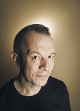 Studio shot man actor model tişört fotoğrafı yaratıcı ışıklandırmayla poz veriyor.
