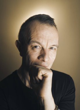 Studio shot man actor model tişört fotoğrafı yaratıcı ışıklandırmayla poz veriyor.