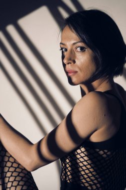 Stüdyoda ışıklandırma efektiyle poz veren duygusal iç çamaşırı modeli..