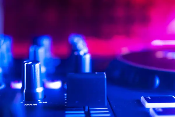 Dj turntables in nightclub electronic music house disco party lights.