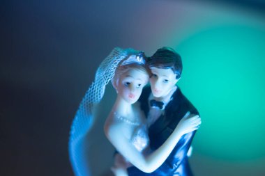 Düğün çifti pasta üstte plastik figürler smokin gece elbisesi, beyaz gelinlik peçesi.