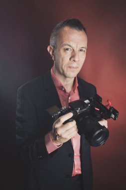 Stüdyoda takım elbiseli bir fotoğrafçı..