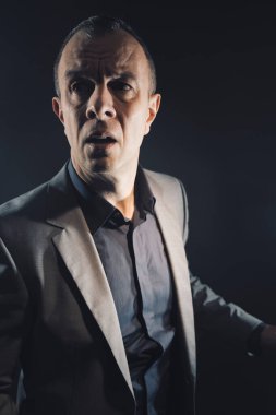 Takım elbiseli bir adam gece korku filmi kapak romanı tasarım fotoğrafı çekmekten korkuyor..