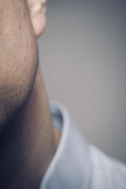 50 'lerin adamı. Gri arka planda çekilmiş yüz ve kulak portresi stüdyosu..