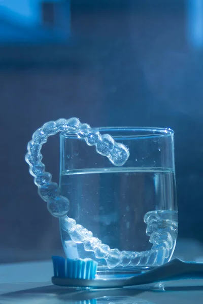 歯科医による歯のアライメントを修正するために使用される現代の目に見えないブラケットアライナーストレーター ストック画像
