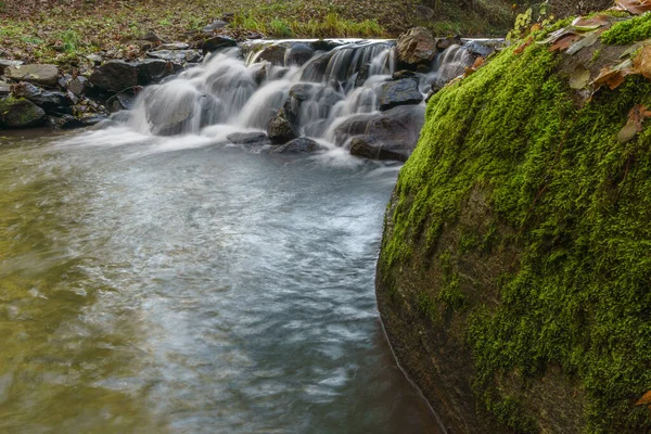 Uma Cachoeira Que Flui Sobre Rochas Musgo — Fotografia de Stock