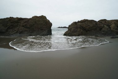 Okyanus gelgiti dalgaları kayaların arasına itiyor