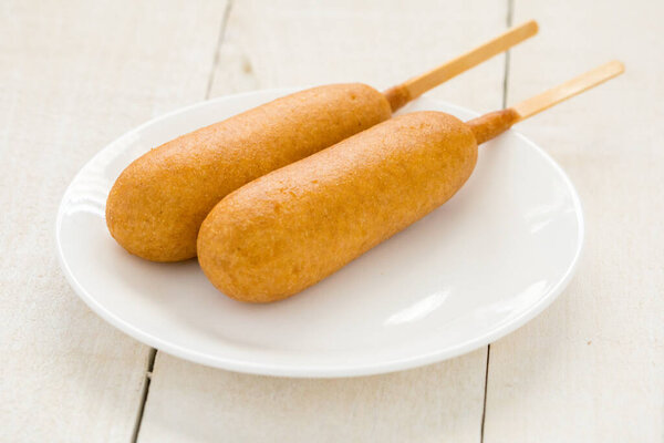 Два корн-дога на белой тарелке