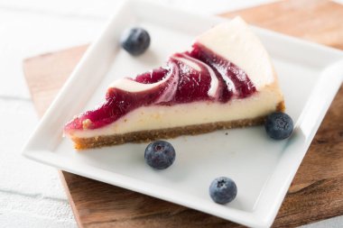 Bir dilim yabanmersinli kremalı cheesecake.