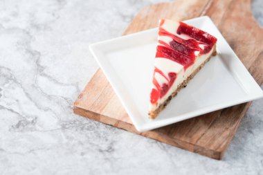 ahududu kıvrımlı cheesecake dilimi kare tabakta