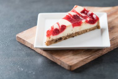 ahududu kıvrımlı cheesecake dilimi kare tabakta