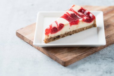 ahududu kıvrımlı cheesecake dilimi kare tabakta