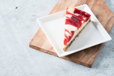 ahududu kıvrımlı cheesecake dilimi kare tabakta