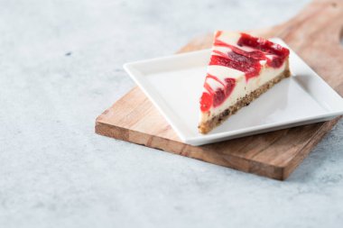 ahududu kıvrımlı cheesecake dilimi kare tabakta