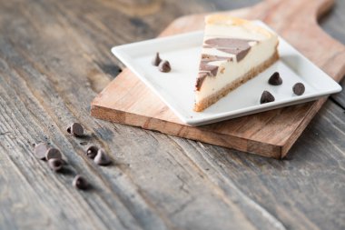 Kare tabakta çikolatalı cheesecake dilimi.