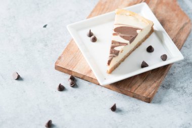 Kare tabakta çikolata kıvrımlı cheesecake dilimi 