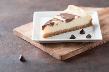 Kare tabakta çikolata kıvrımlı cheesecake dilimi