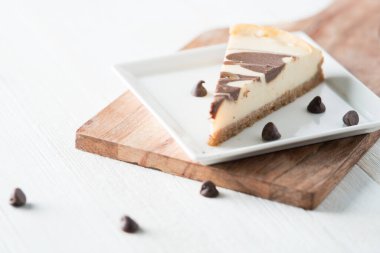 Kare tabakta çikolata kıvrımlı cheesecake dilimi